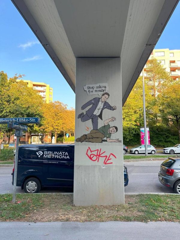 "Хватит клянчить деньги!": в немецком Мюнхене появилось изображение Илона Маска, пинающего Зеленского